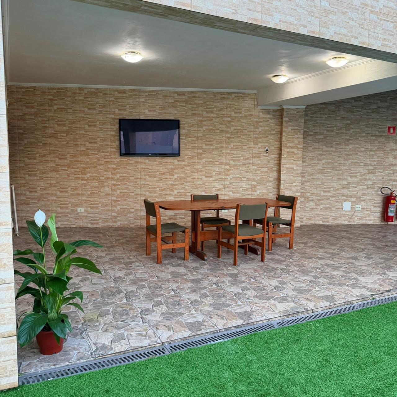 Mesa de refeições na área coberta e jardim